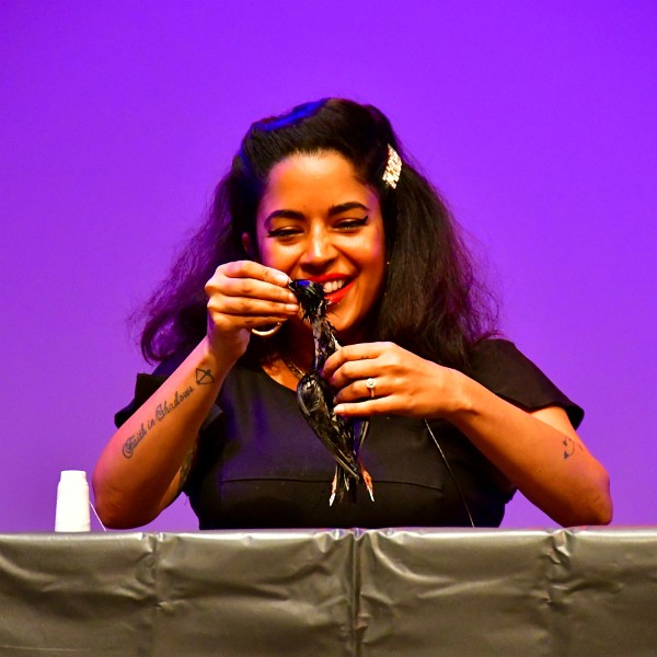 Divya Anantharaman Smiling While Creating a Taxidermied Starling Live Onstage